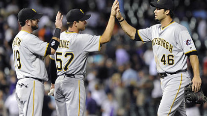 The Pirates' Garrett Jones, right, is congratulated by Ryan Church, left, and Zach Duke, center, after defeating the Rockies, 6-2.
