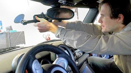 Spike Katora works on placing the camera on the winshield of a Mini at P&W Automotive.