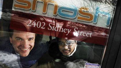 Eric Boduch, left, and Chanakya Damarla, co-founders of Smash, look through their front office door on the South Side.  Smash deals with text messaging on the phone in business.