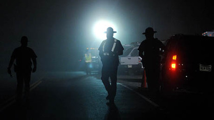 West Virginia State Police officers direct traffic in front of an entrance to Massey Energy's Upper Big Branch mine in Raleigh County after an explosion there killed at least 25 people, Monday.