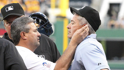 Pirates athletic trainer Mike Sandoval, left, checks umpire John Hirschbeck after he was hit by a first-inning warmup pitch by the Brewers' Chris Narveson.