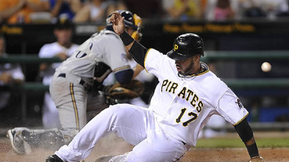 The Pirates' Pedro Alvarez slides safely in to home.