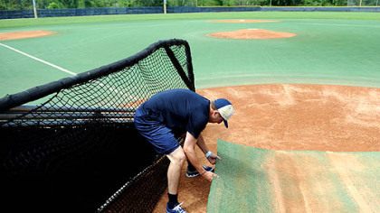 Pitt player Corey Baker pulls a mat over home plate while preparing Trees Field for the weekend series vs. South Florida, the Panthers' final games at Trees Field.