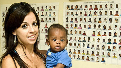 Jamie McMutrie with a child waiting for adoption last year at the BRESMA orphanage in Port-au-Prince, Haiti.