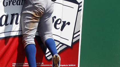 Cubs left fielder Alfonso Soriano runs in to the outfield wall after failing to run down an eighth-inning triple by the Pirates Andrew McCutchen.