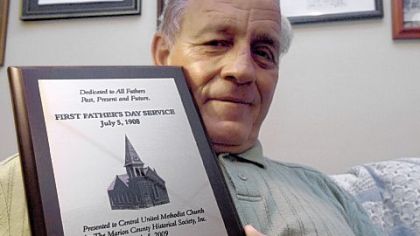 The Rev. D.D. Meighen holds a plaque commemorating the first Father's Day service in memory  of those who died in the Monongah mine explosion.