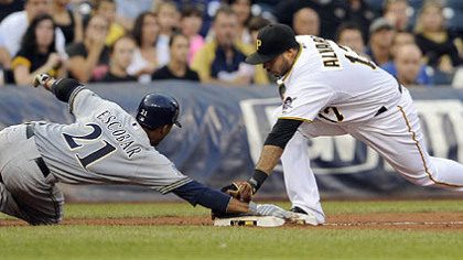 The Brewers' Alcides Escobar slides safely into third base against the Pirates' Pedro Alvarez in the third inning.