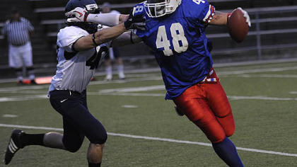 The Pittsburgh Colts' Earl Work  fends off the Lancaster Lightening's Tim Mathna during a game at Ambridge Area High July 31.
