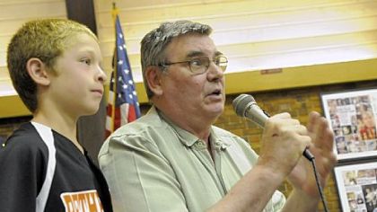 John Kovach, right, is honored last Thursday by the Bethel Park school board for saving Dylan Dowd, 9, a student at Memorial Elementary School who was choking during lunch.