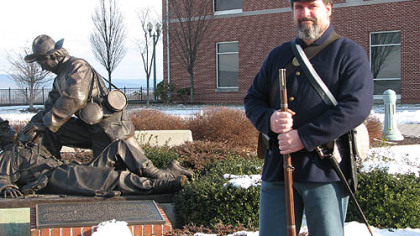 Curator Brett Kelley stands beside the Moment of Mercy statue in front of The National Civil War Museum in Harrisburg.