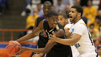 Washington's Justin Holiday looks to pass against West Virginia's Devin Ebanks.