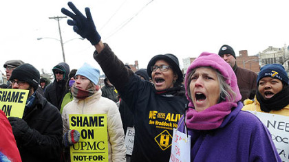 Delia Winstead, center, of Braddock, and Jan McMannis, of Braddock Hills, chant slogans Saturday during a rally protesting the closing of UPMC Braddock hospital, which is set to close today. About 200 people participated in the rally.