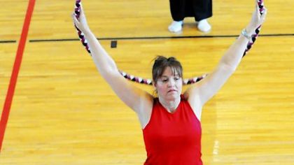 Three aerobics students stretch using hula hoops during a fitness class that combines hooping and Pilates at the Peters Township Community Recreation Center.