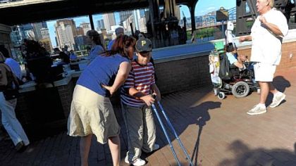 Julie Leckenby of Mt. Lebanon speaks to her son, Joseph Leckenby, 11, as they watch a performance at the street festival at Station Square on Monday that followed a community forum marking the 20th anniversary of the signing of the Americans with Disabilities Act.