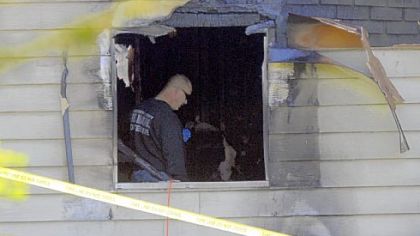 An Allegheny County Fire Marshall's detective investigates the scene of a house fire on Locust Lane in South Fayette, where a woman's body was found on Friday.