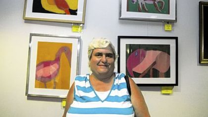 Sheryl Yeager, of Crafton, stands on Friday in front of her pastel art of birds and other animals at the 23rd Flowering of Insight art exhibit of works created by adult participants of the Allegheny County Department of Human Services programs.