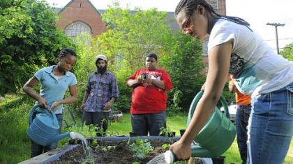 Ceasia Williams, 14, left, and Jayda Harden, 14, water newly planted seedlings in a raised bed for the Lots of Hope gardening project at The Pittsburgh Project on the North Side.