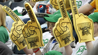 Pirates fans wave foam rubber hands and wear green ball caps as they cheer in the sixth inning.