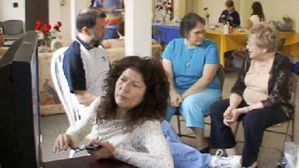 Laurel Krause (left foreground) checks the live feed from the Kent State Truth Tribunal, a series of taped interviews she organized in a final search for details about the May 4, 1970, shooting that killed four students, including her older sister, Allison. At far right is Doris Krause, the mother of the two women.