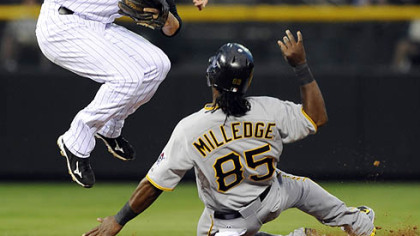 The Pirates' Lastings Milledge slides into second after being forced as Rockies second baseman Clint Barmes throws to first base to turn the double play on the Pirates' Ronny Cedeno in the sixth inning.