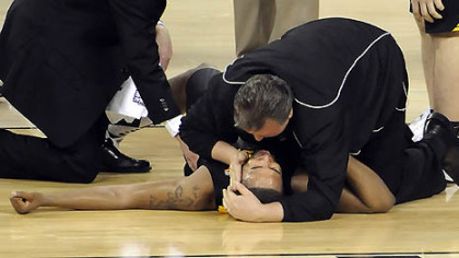 West Virginia coach Bob Huggins comforts Da'Sean Butler after Butler injured his leg against Duke in the second half of the semifinal game in the NCAA tournament in Indianapolis last night.