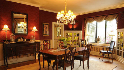 The dining room features a 12-light brass chandelier and lighted corner china cabinets. The 5-by-7-foot picture window and window seat overlook a fenced, level backyard.