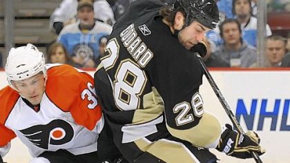 Eric Godard battles for the puck with the Flyers' Darroll Powe last night at Mellon Arena.