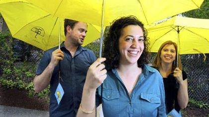 Julie Kresen, flanked by Geoff Barnes and Katy DeLancey, are the team behind "Here You Go," where distinctive yellow umbrellas are given to someone stranded in the rain and the recipients are asked to do a good deed for someone else.