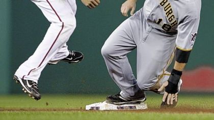 The Pirates' Neil Walker beats Nationals shortstop Ian Desmond to second base before continuing to third base on Nationals catcher Will Nieves' throwing error during the fourth inning of Wednesday's game at Nationals Park in Washington.