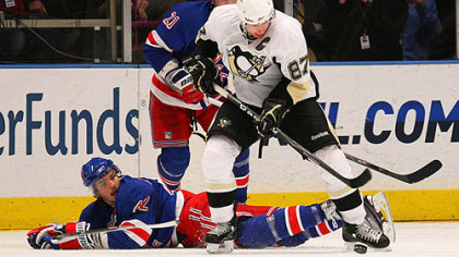 Penguins forward Sidney Crosby and Rangers forward Artem Anisimov battle for control of the puck.