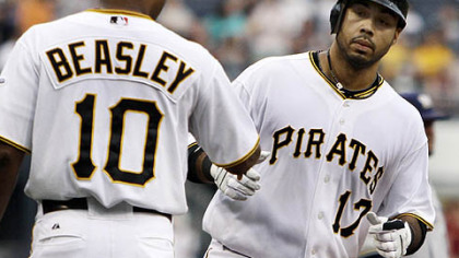 The Pirates' Pedro Alvarez rounds third to greetings from coach Tony Beasley after hitting a grand slam off Brewers pitcher Dave Bush in the first inning.
