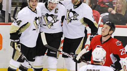 Sidney Crosby, center, celebrates one of his two second-period goals with teammates Chris Kunitz, left, and Bill Guerin as Ottawa's Chris Neil looks on. The Penguins scored five goals in the period en route to a 7-4 victory in Game 4 at Scotiabank Place in Ottawa.