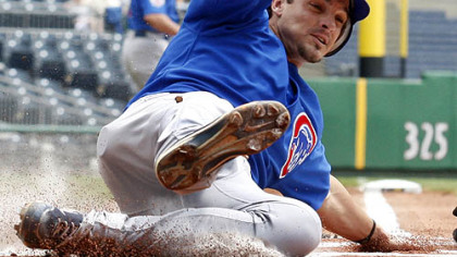 The Cubs' Ryan Theriot scores on a first-inning sacrifice fly to center field by the Cubs' Jeff Baker.