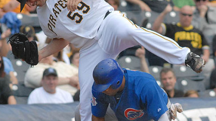 Pirates pitcher Dana Eveland untangles himself from the Cubs' Marion Byrd.
