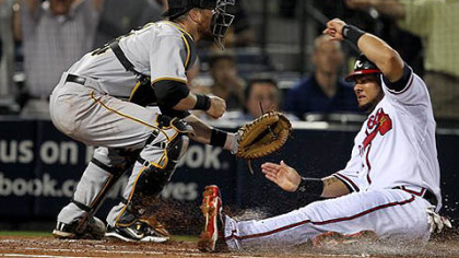 Atlanta Braves' Melky Cabrera, right, scores on a Troy Glaus double as  Pirates catcher Ryan Doumit waits for the throw.
