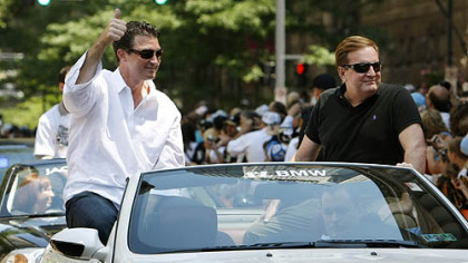 Mario Lemieux, left, and Ron Burkle ride together in the Stanley Cup parade last June.