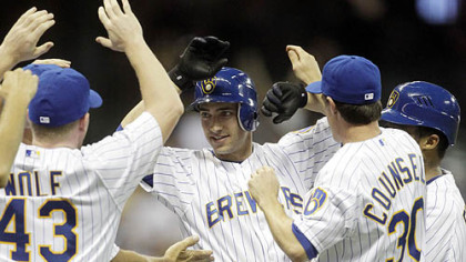 The Brewers' Ryan Braun is mobbed by teammates after getting the game-winning hit during the 10th inning.