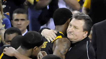 West Virginia coach Bob Huggins hugs Devin Ebanks near the end of his team's loss to Duke in the semifinal game in the NCAA tournament in Indianapolis last night.