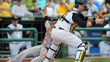 The Giants' Freddy Sanchez slides past Pirates catcher Ryan Doumit in the fifth inning Sunday at PNC Park.