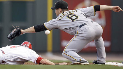 Pirates first baseman Jeff Clement misses a pickoff throw from pitcher Ross Ohlendorf as the Reds' Drew Stubbs dives safely back to first base in the second inning. Clement was charged with an error allowing Stubbs to advance to second.