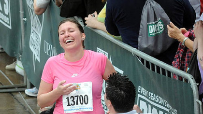 Martin Perry, wearing a white shirt, gets on his knees to propose to Kristen Kostelich just as she is about to cross the finish line. The couple is from Baldwin.