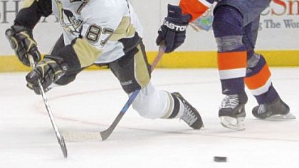 Sidney Crosby passes the puck in front of the Islanders' Andy Sutton in the third period.