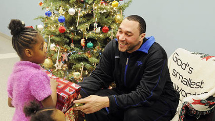 Steelers player Charlie Batch gives a present to Shaterra Lee, 5, who is at the Salvation Army with her mother as part of the Best of the Batch Foundation activities.