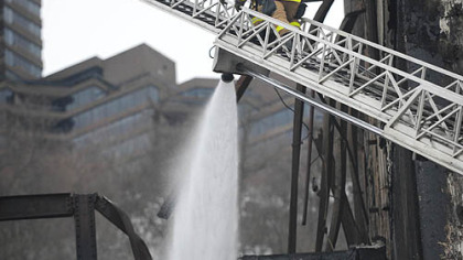 Firefighters douse the remains of a vacant warehouse on West Carson Street.