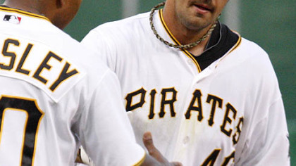 The Pirates' Garrett Jones rounds third to greetings from coach Tony Beasley after hitting a solo home run off Cubs pitcher Ted Lilly in the fourth inning.
