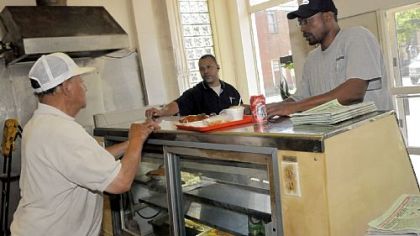 George Wilson, left, owner of Wilson's Bar B-Q on the Central North Side, waits on customers Rick Weaver, center, and Romir Miller on Thursday. Wilson's has been in business for 50 years.