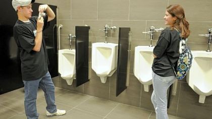Shane Tappe and Sarah Roth, both of Shaler Area High School, take pictures in a bathroom at the Consol Energy Center during Thursday's "Student Flush" plumbing test.