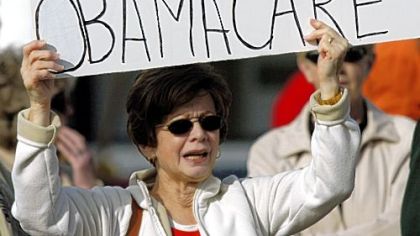 Karen Bills, of Delmont, protests Tuesday against health care reform near U.S. Rep. Jason Altmire's office in Aliquippa.