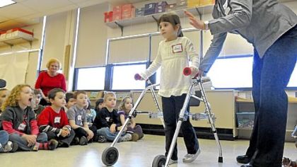Kindergarten student Sami Garbowsky learns to use a walker at the Gill Hall Elementary School as their class learns about disabilities and how people live with them from Easter Seals of Western Pennsylvania Integration Support Specialist Betsy Smith. Gill Hall Elementary is in the West Jefferson Hills School District.