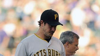Pitcher Ross Ohlendorf is ushered off the field by the Pirates' athletic trainer, Brad Henderson, after being struck in the head by a line drive in the first inning Wednesday at Coors Field.